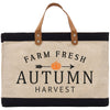 A beige tote bag with a black trim and a leather handle, featuring the text "FARM FRESH AUTUMN HARVEST" printed on it.
