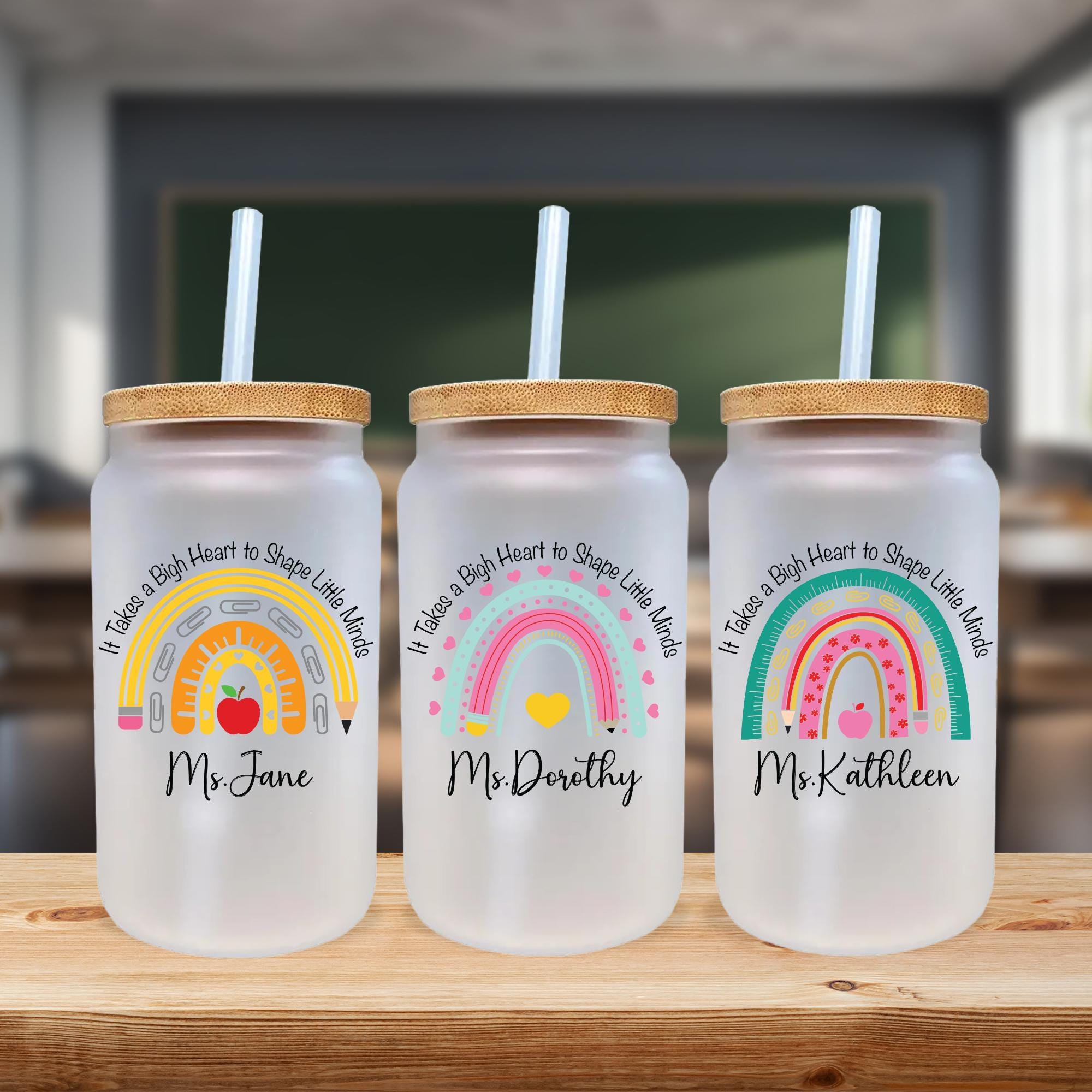 three personalized mason jars with straw tops on a table