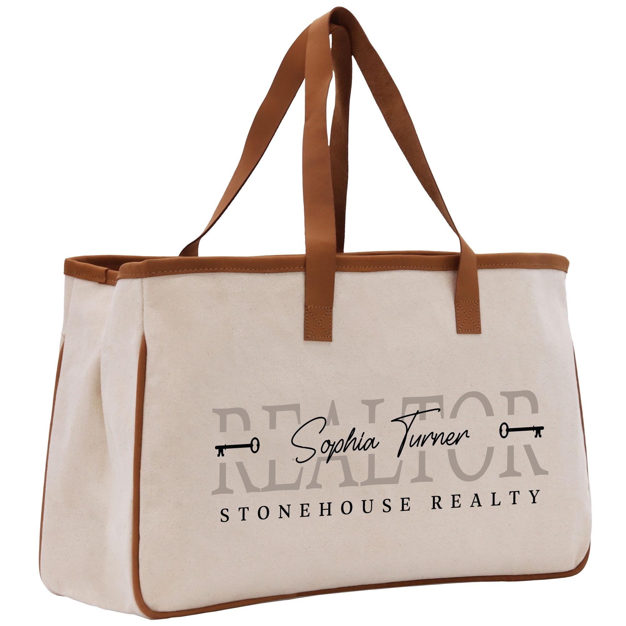 a white canvas bag with a brown leather handle