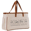 a white canvas bag with a brown leather handle