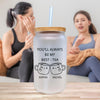 two women sitting on a couch with a drink in front of them