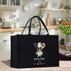 A black tote bag with a design of baking utensils and the text "Baking with Alice" printed on it, placed on a kitchen counter.