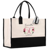 a black and white bag with a pink flower on it