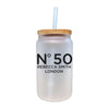 A frosted glass jar with a straw, featuring the text "N°50 Rebecca Smith London" printed on it.