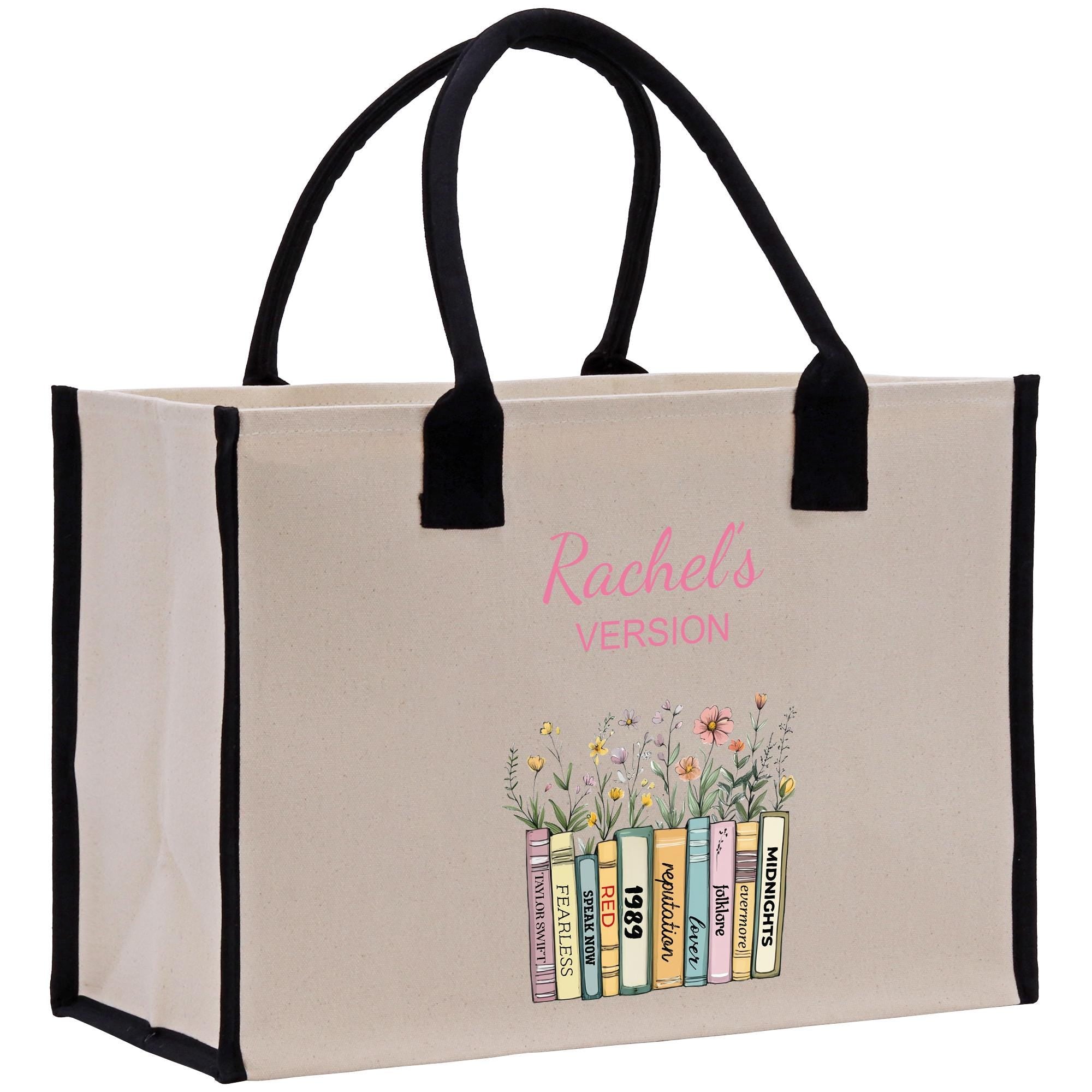 A beige canvas tote bag with black handles and straps, featuring a printed design of a bookcase with colorful books and flowers.
