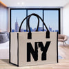 a new york bag with the statue of liberty in the background