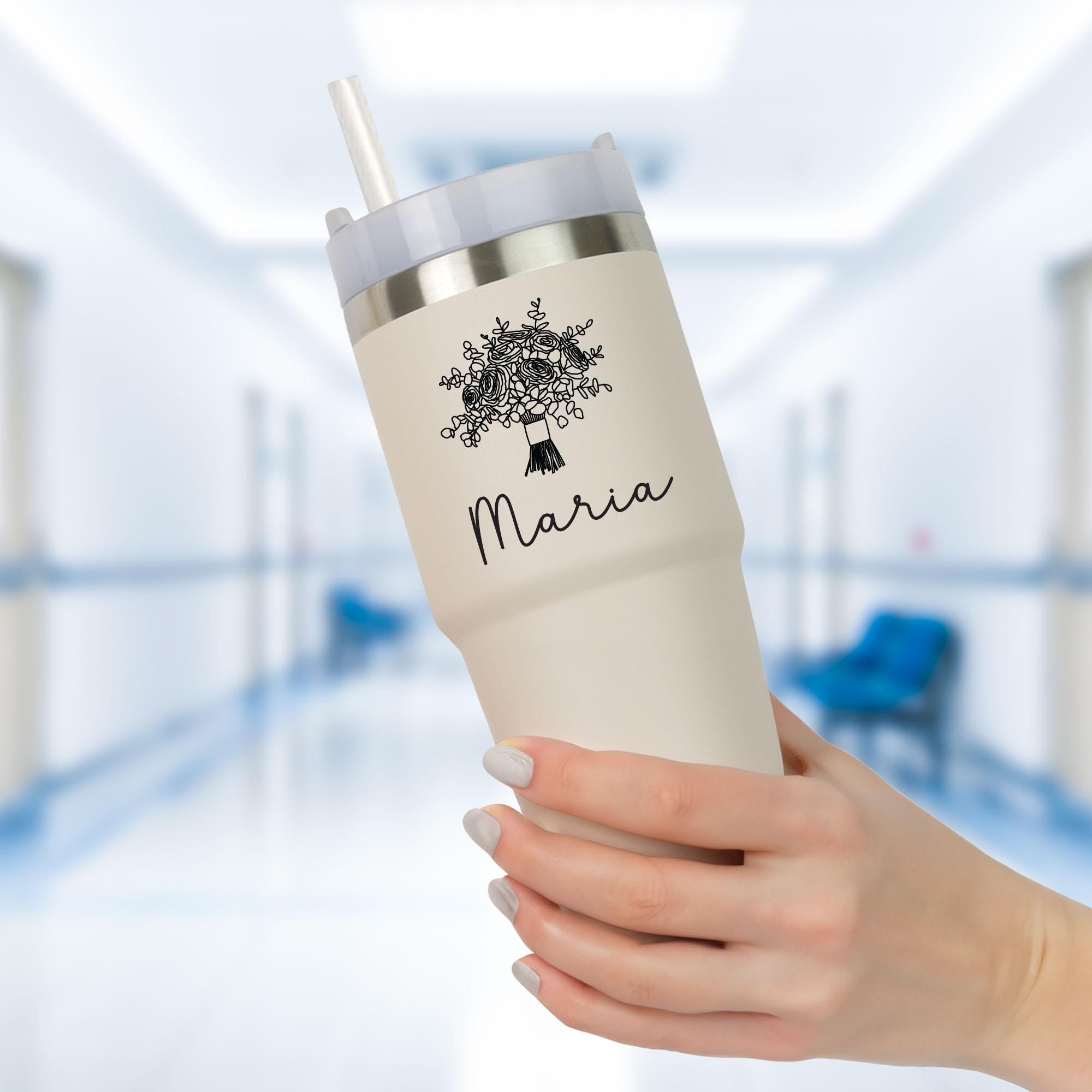a person holding a white cup with a tree on it