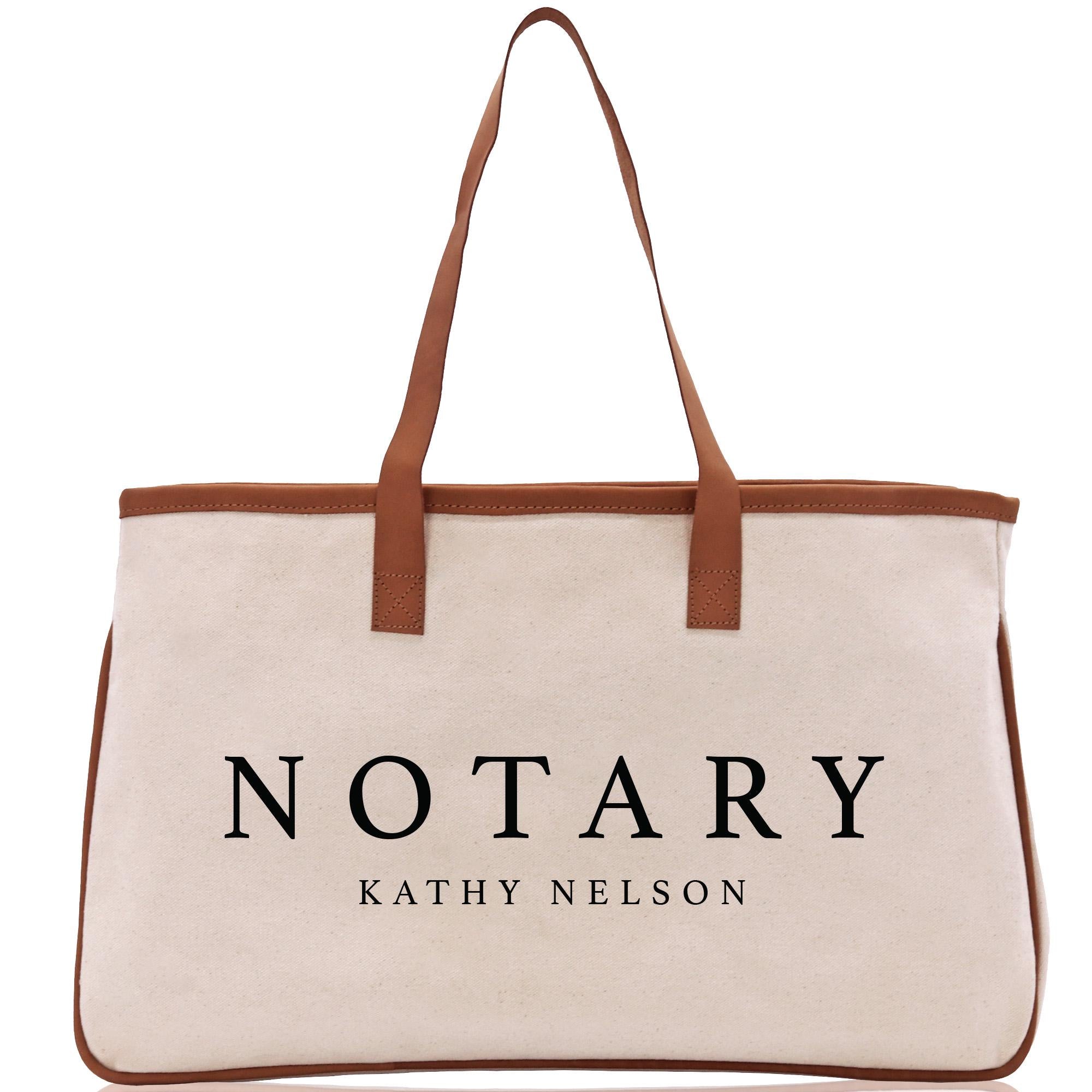 A beige canvas tote bag with the word &quot;NOTARY&quot; printed on it in black text.
