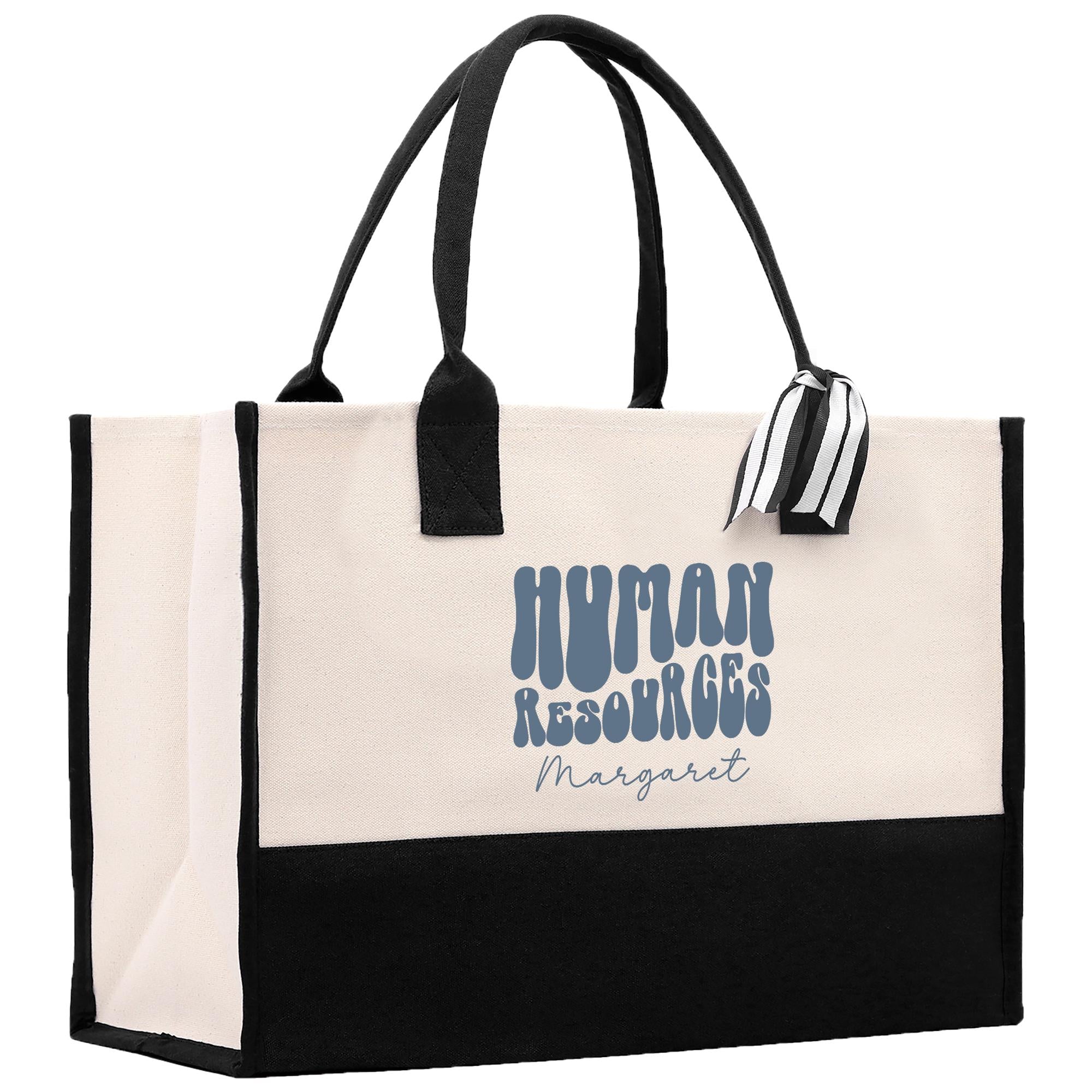 A beige tote bag with black handles and straps, featuring a logo and text on the front.
