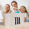 a woman and two girls sitting at a table with a bag