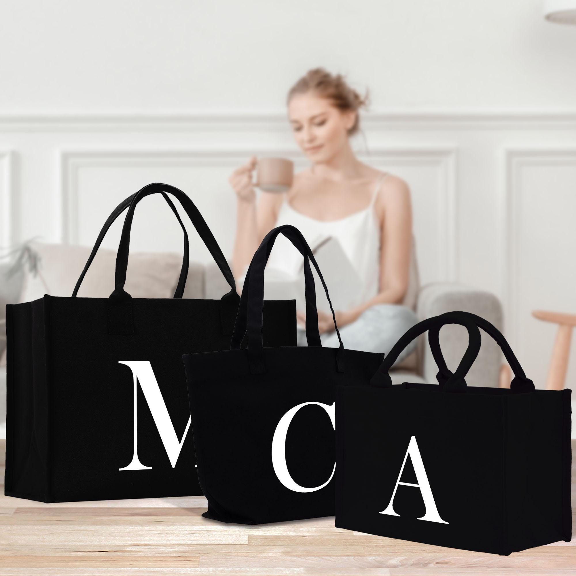 a woman sitting on a couch next to three black bags