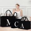a woman sitting on a couch next to three black bags