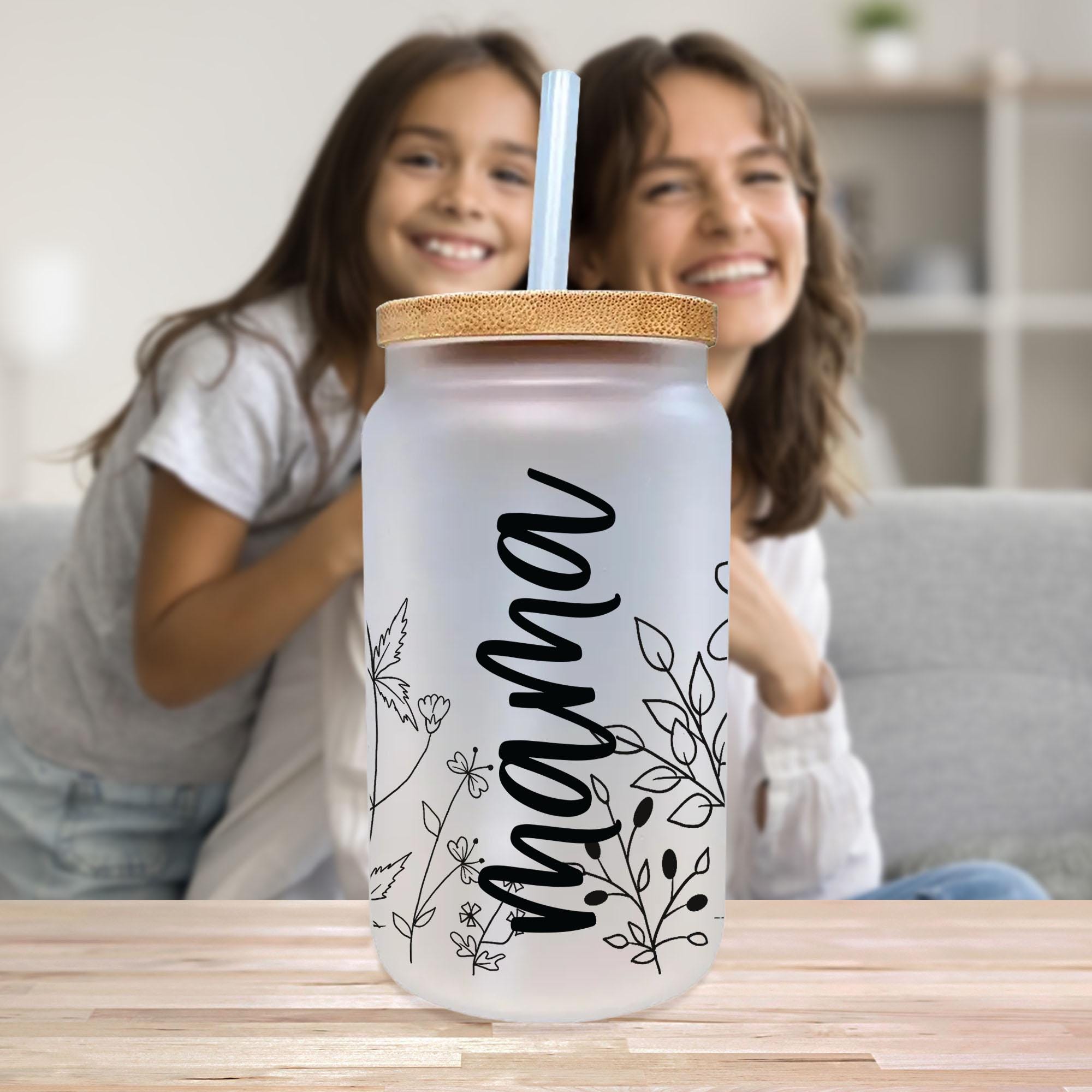 a woman and a girl sitting on a couch with a drink in front of them