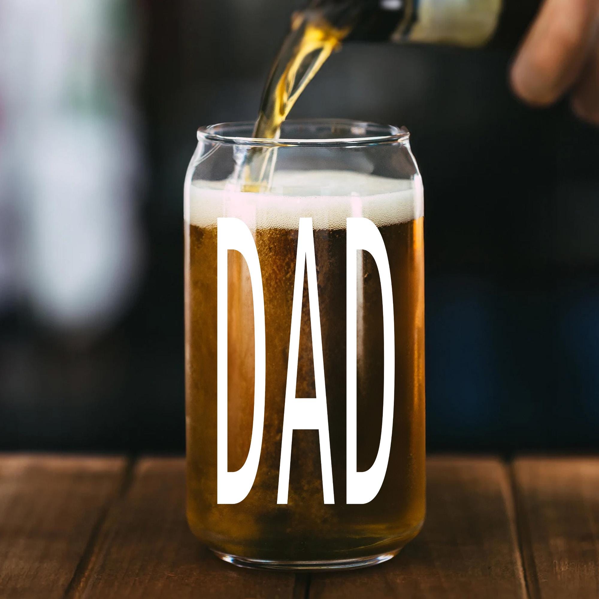A glass of beer with the word &quot;DAD&quot; printed on it, with a stream of beer being poured into the glass.