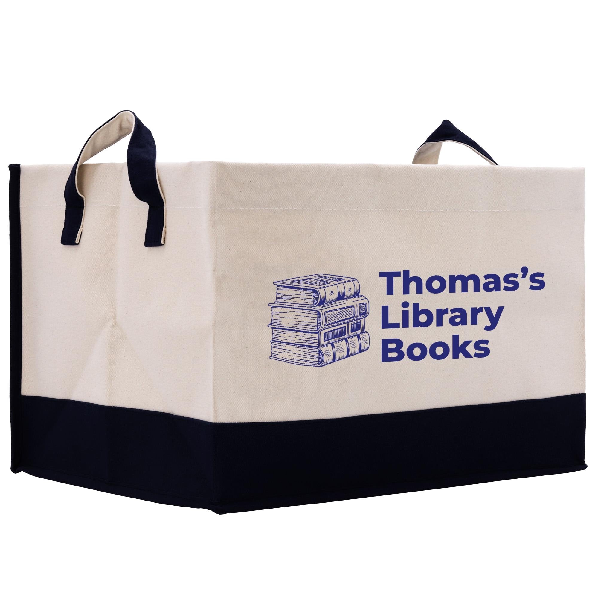 A beige tote bag with a black trim, featuring a graphic of a stack of books and the text &quot;Thomas&#39;s Library Books&quot; printed on it.