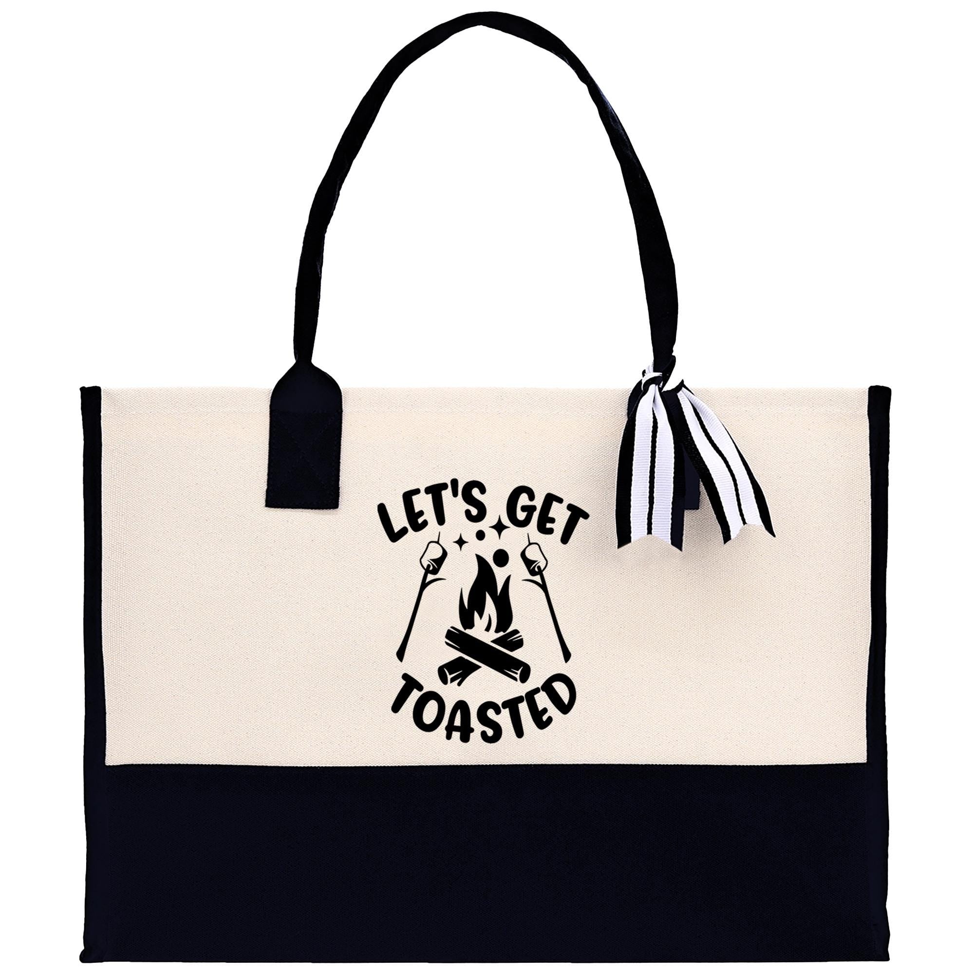 A tote bag with a black and white design featuring the text "Let's Get Toasted" and an illustration of a campfire.