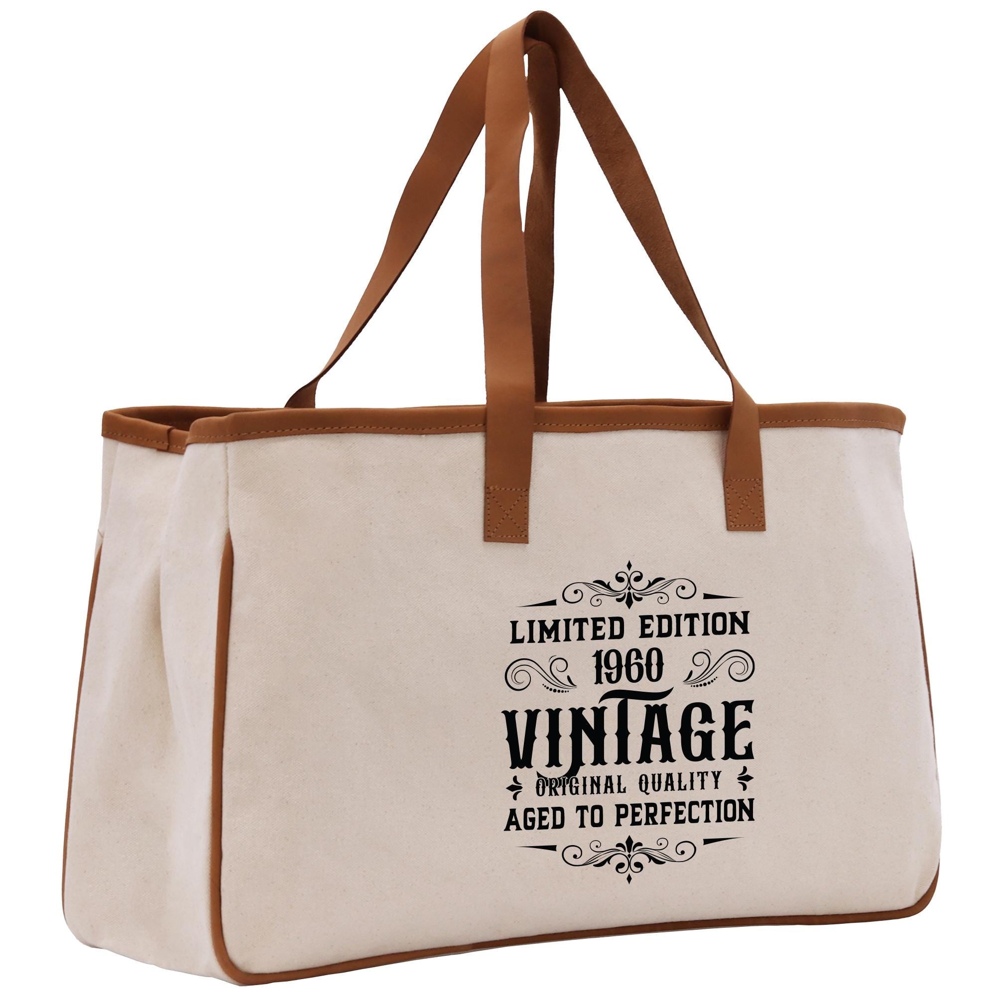 A beige canvas tote bag with a brown handle and a printed design on the front.
