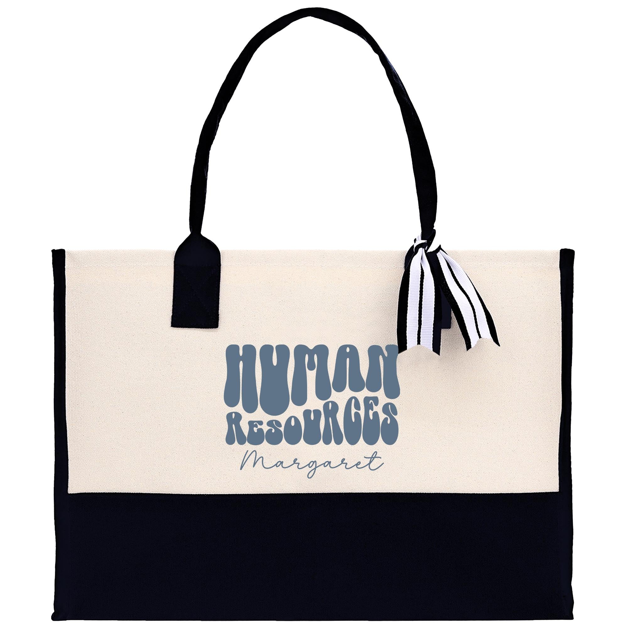 A beige tote bag with a black handle and a black and white striped ribbon tied around it. The bag has a logo printed on it that says &quot;Human Resources Margaret&quot;.