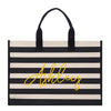 A black and white striped tote bag with the name "Ashley" printed in yellow on it.