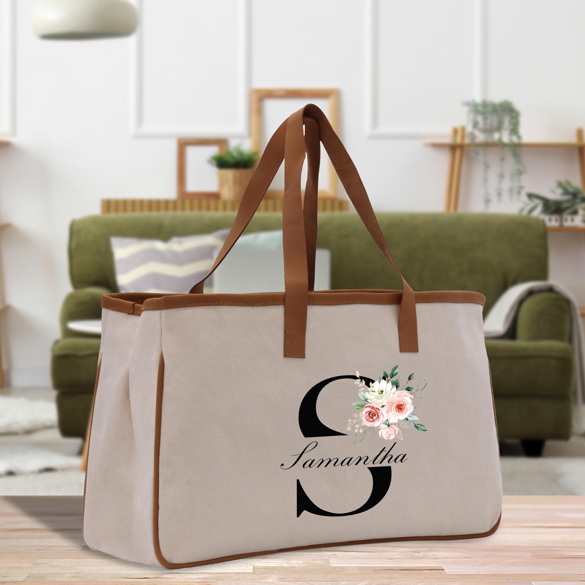 a canvas tote bag with a floral monogrammed initial