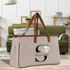 a canvas tote bag with a floral monogrammed initial