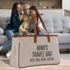 a couple of women sitting on a couch next to a bag