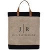 A beige tote bag with a black trim and leather handles, featuring the text "Jil'l Rae Designs" printed on it.
