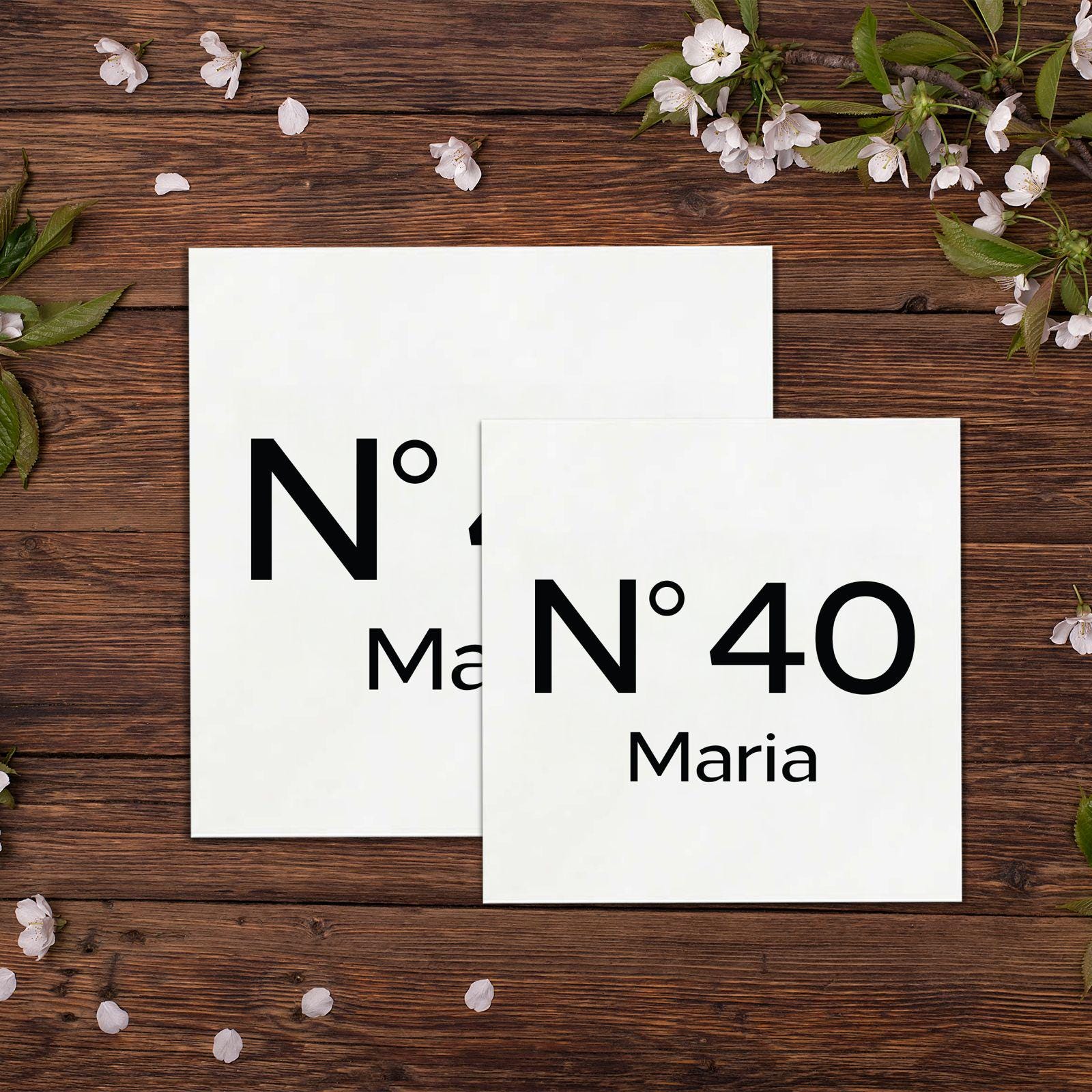 two pieces of paper sitting on top of a wooden table