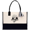 A beige tote bag with a black and white graphic design on the front, featuring a sun and mountain silhouette, along with the word 