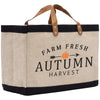 A beige tote bag with black trim and a brown leather handle, featuring the text "FARM FRESH AUTUMN HARVEST" printed on it.