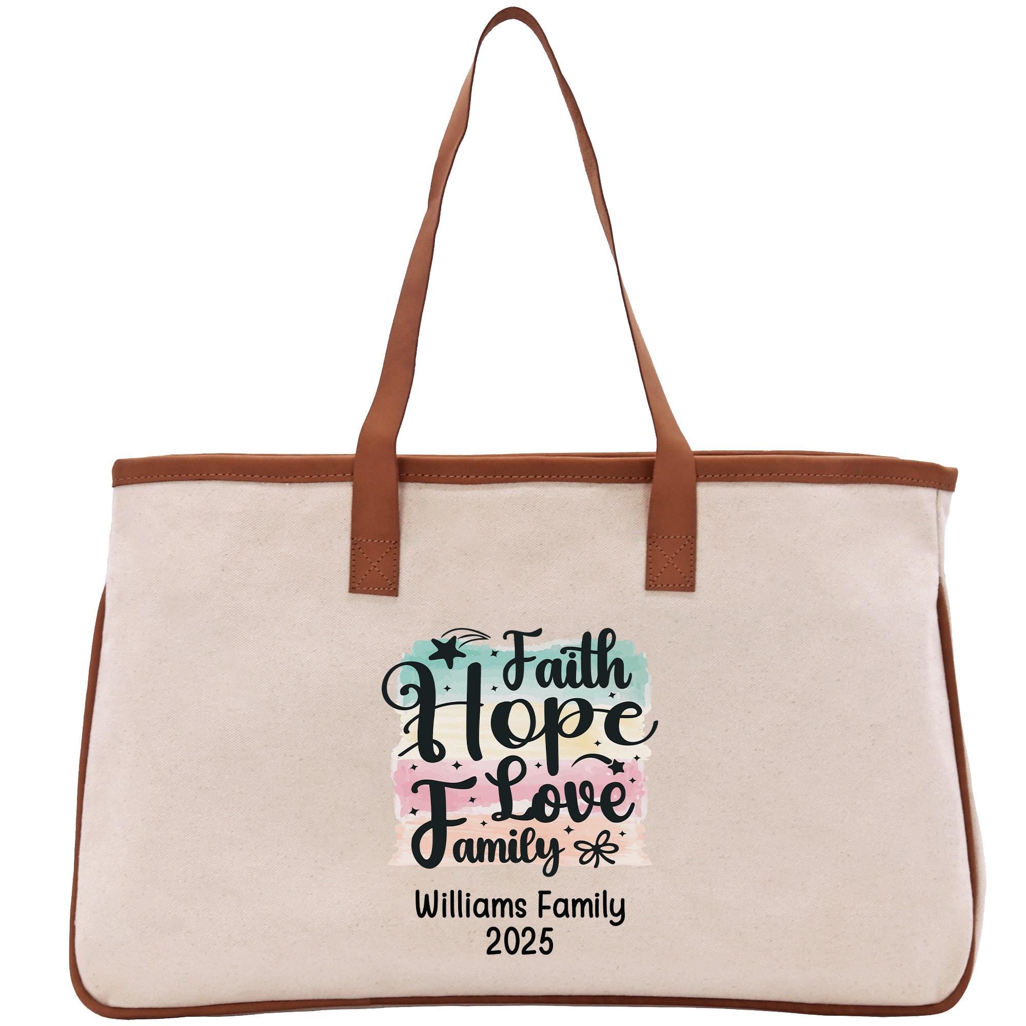 A beige canvas tote bag with a brown leather strap and a printed design on the front that says &quot;Faith Hope Love Family&quot; and &quot;Williams Family 2020&quot;.