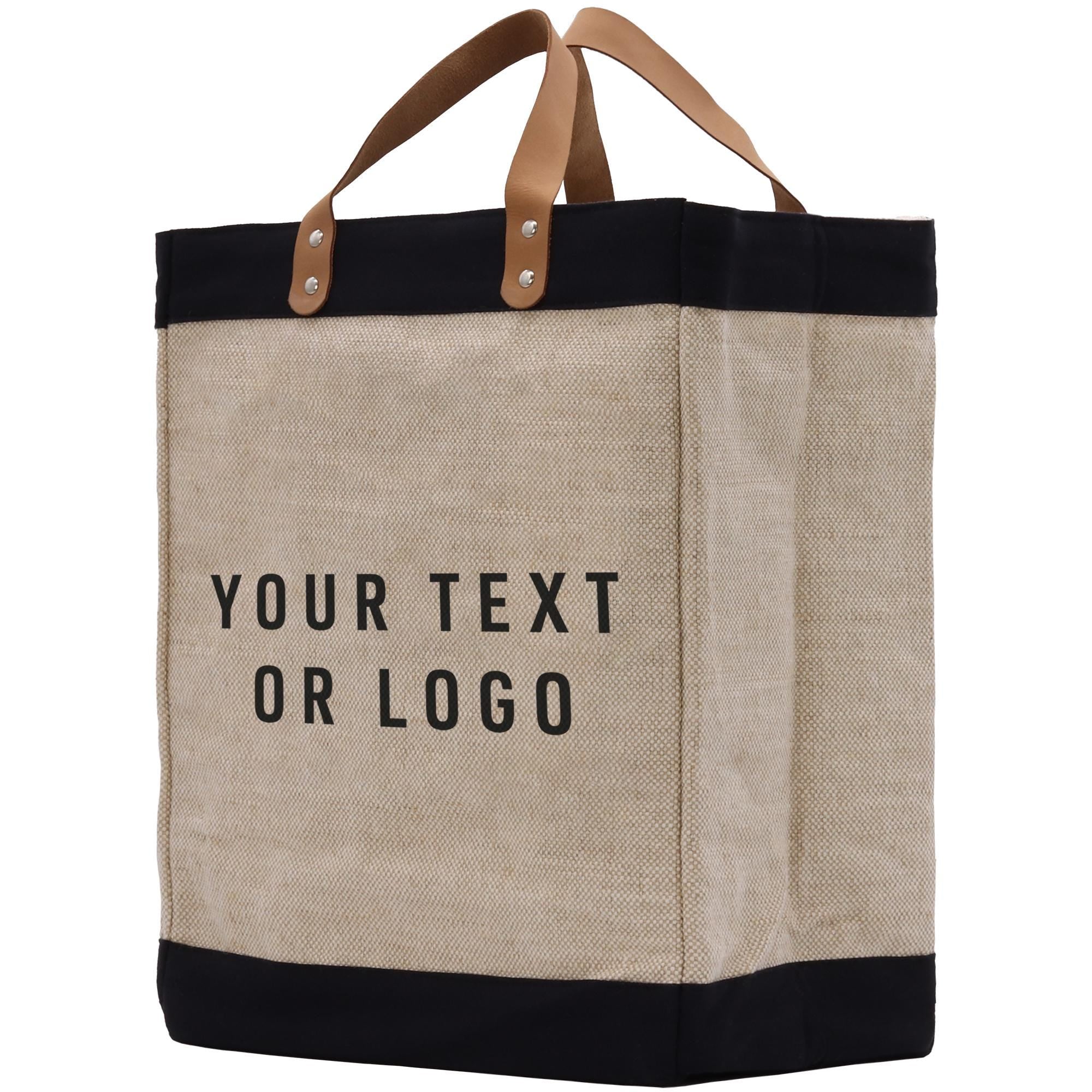 A beige tote bag with black trim and leather handles, featuring the text &quot;YOUR TEXT OR LOGO&quot; printed on it.