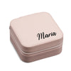 A pink, square-shaped makeup case with the name "Maria" printed on it.