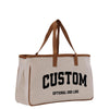 a white canvas bag with a brown leather handle