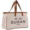 A beige canvas tote bag with brown straps and the text "N° 30 SUSAN TEXAS" printed on it.