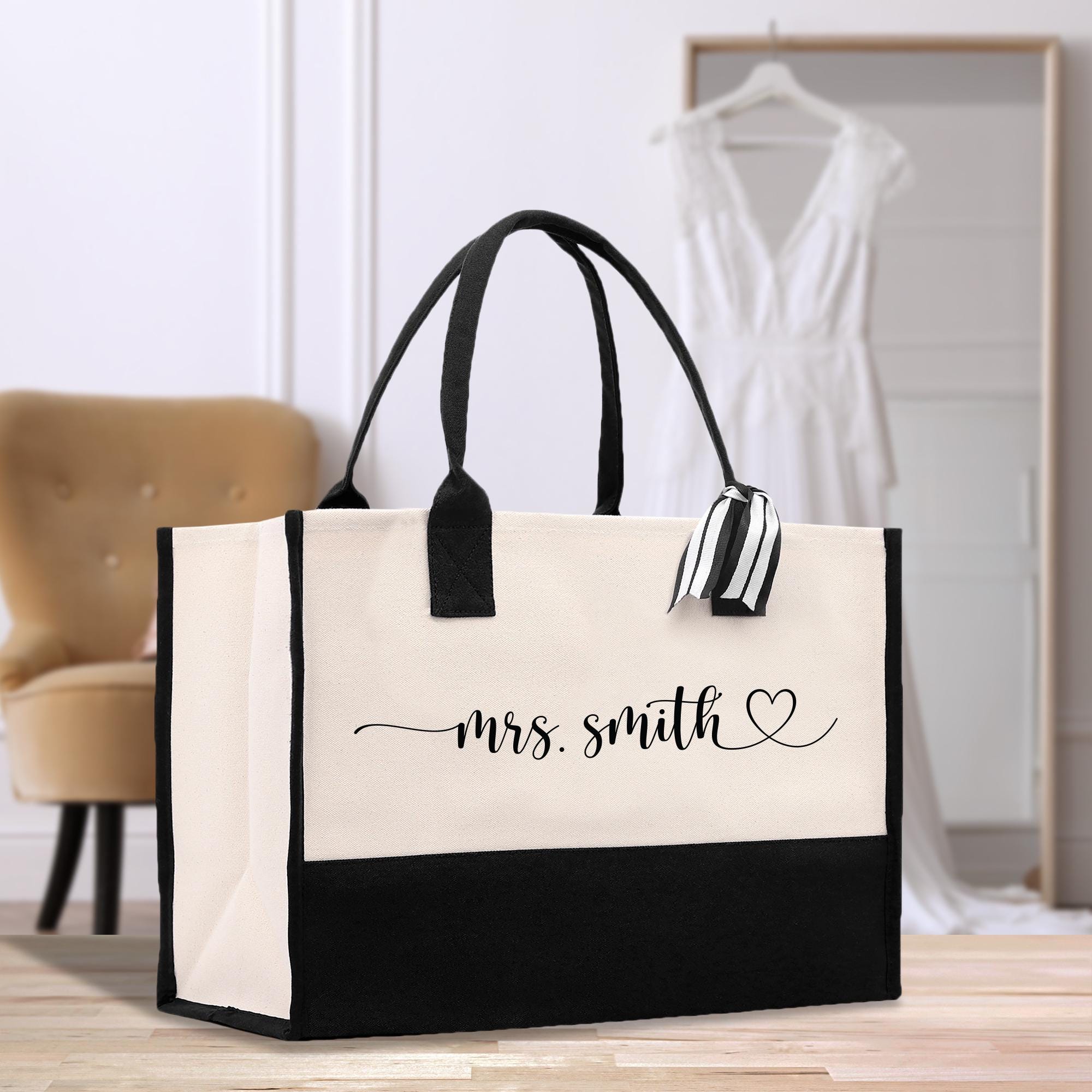 a black and white tote bag sitting on top of a wooden floor