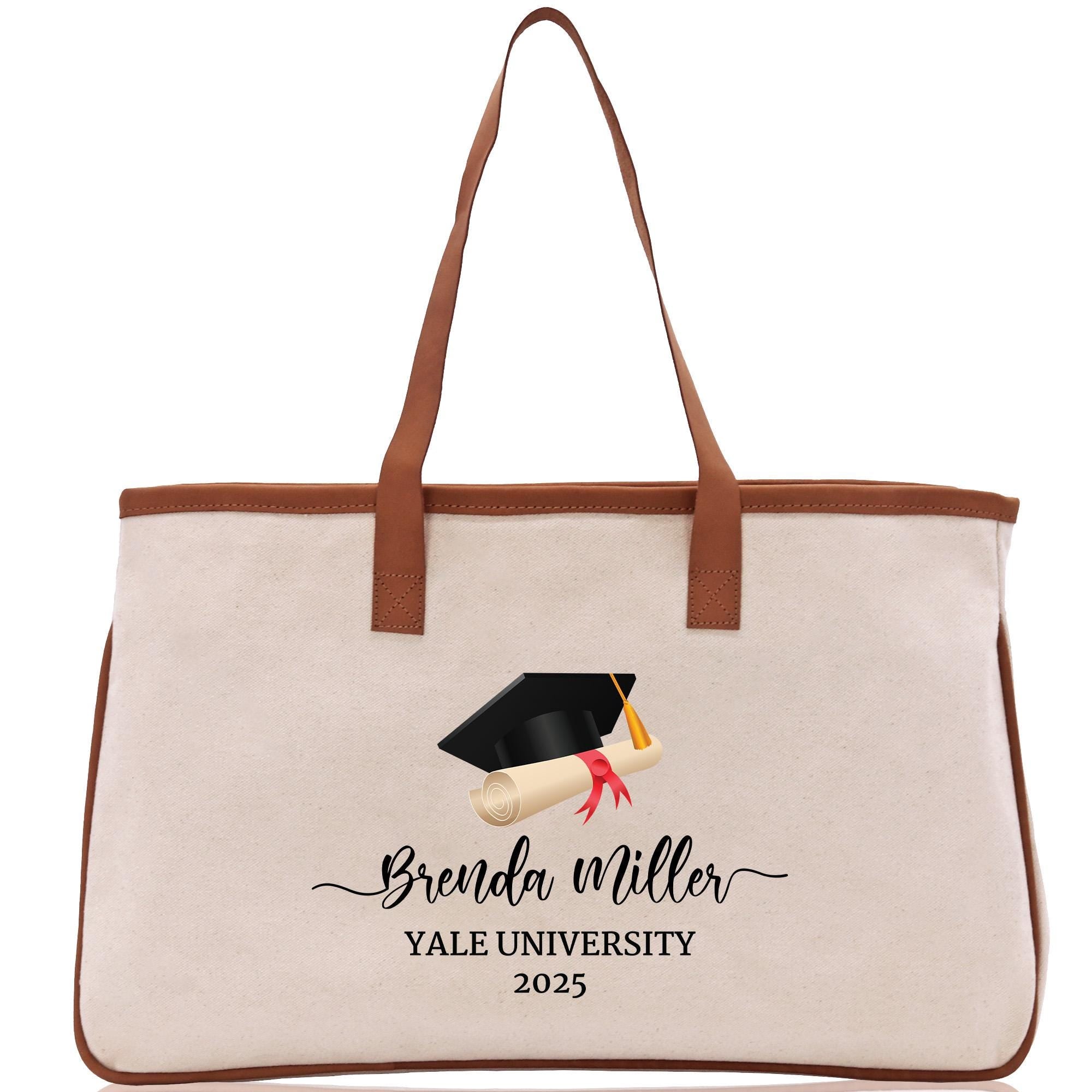 A beige tote bag with a graduation cap and mortarboard printed on it, along with the text &quot;Benda Miller Yale University 2020&quot;.