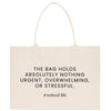 a beige tote bag with a printed quote that reads: "THE BAG HOLDS ABSOLUTELY NOTHING URGENT, OVERWHELMING, OR STRESSFUL."