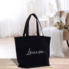 a black tote bag sitting on top of a wooden floor