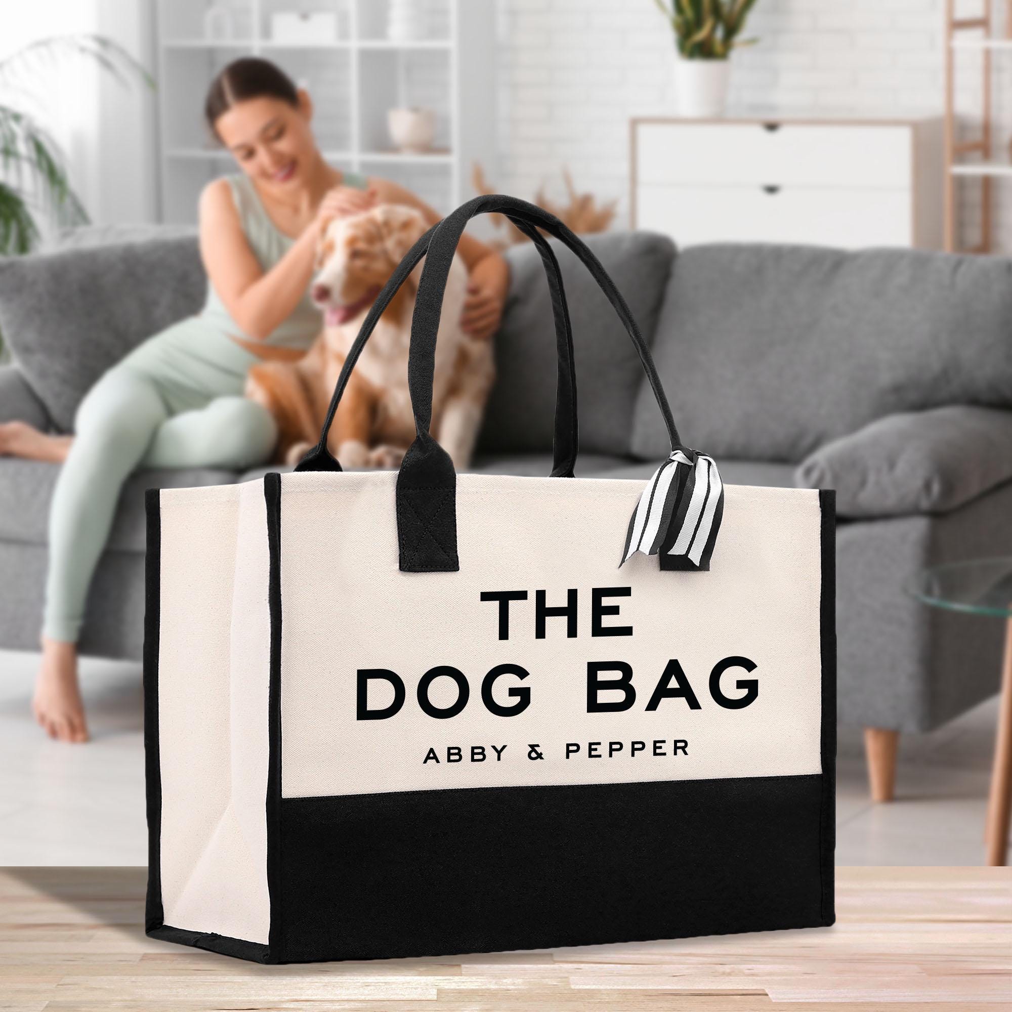 a woman sitting on a couch with a dog in a bag