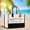 a black and white beach bag sitting on top of a wooden table