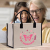 an older woman and a young girl sitting at a table with a shopping bag