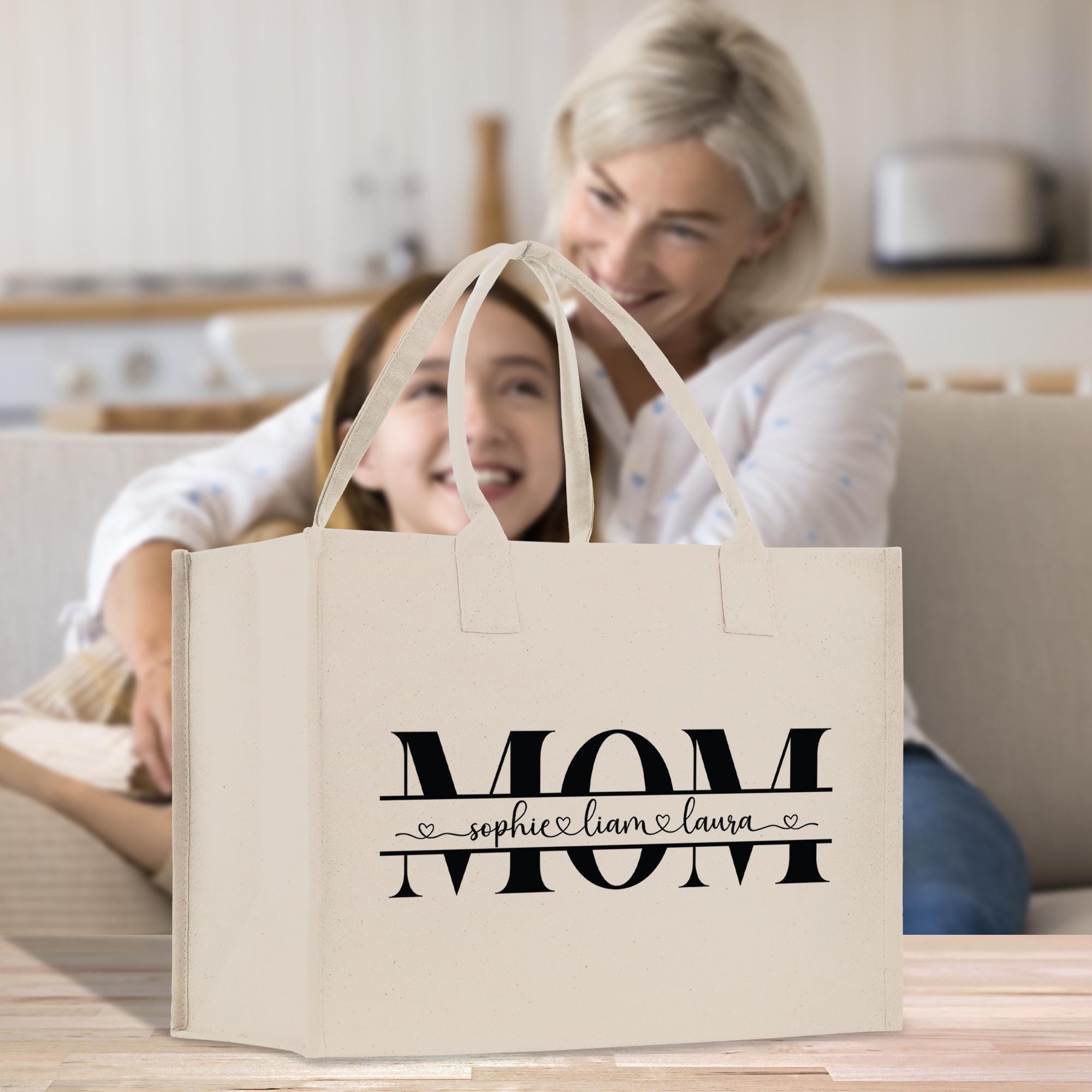 a mother and daughter sitting on a couch with a shopping bag