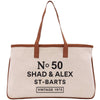 A tan tote bag with brown straps and text printed on it.