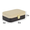 A rectangular jewelry box with a beige top and black bottom, featuring a gold clasp. The box is approximately 2 inches in length, 6 inches in width, and 4 inches in height.