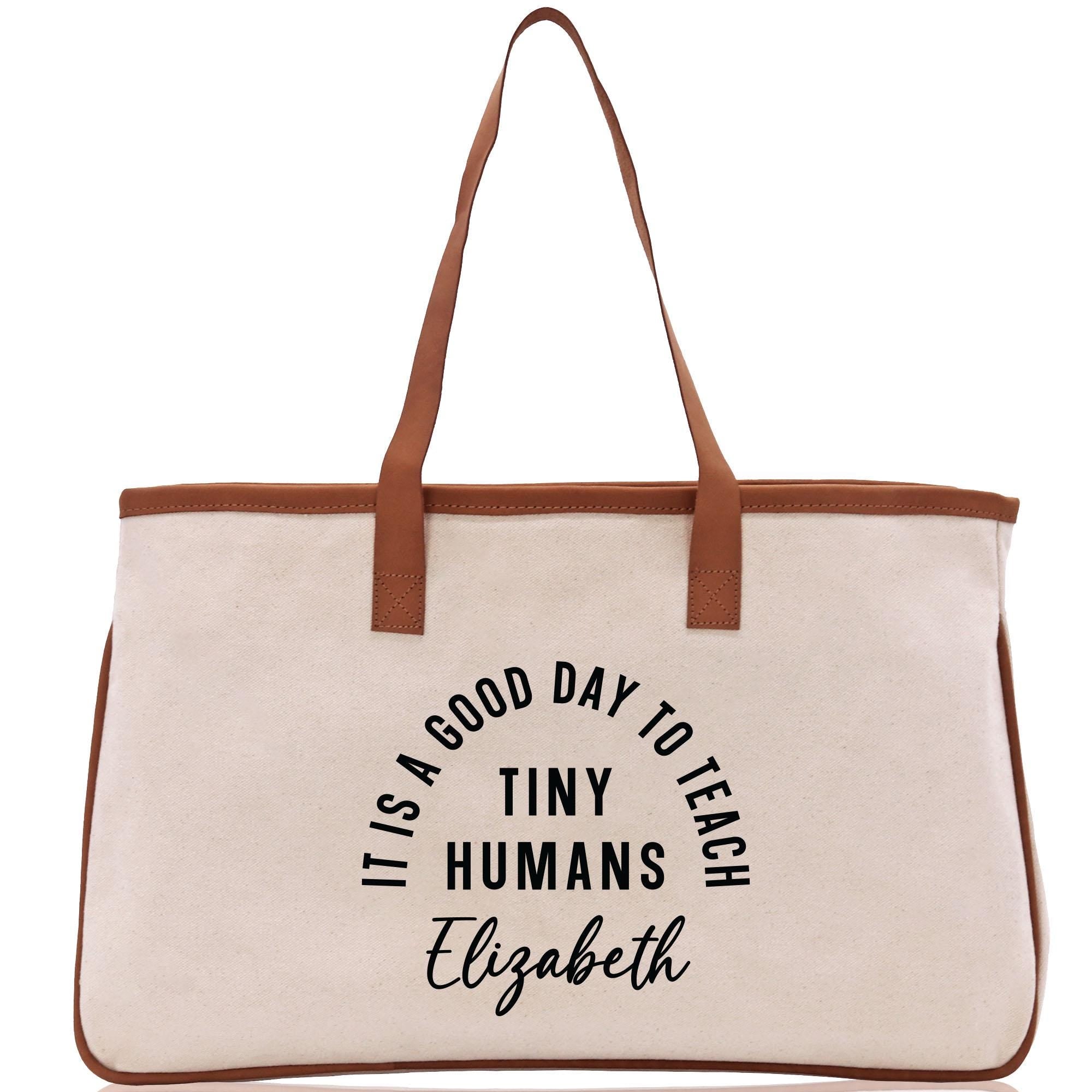a white bag with a brown leather handle