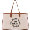 a white bag with a brown leather handle