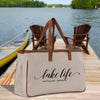 a lake life tote bag sitting on a dock