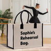 a woman in a black dress is dancing behind a white bag