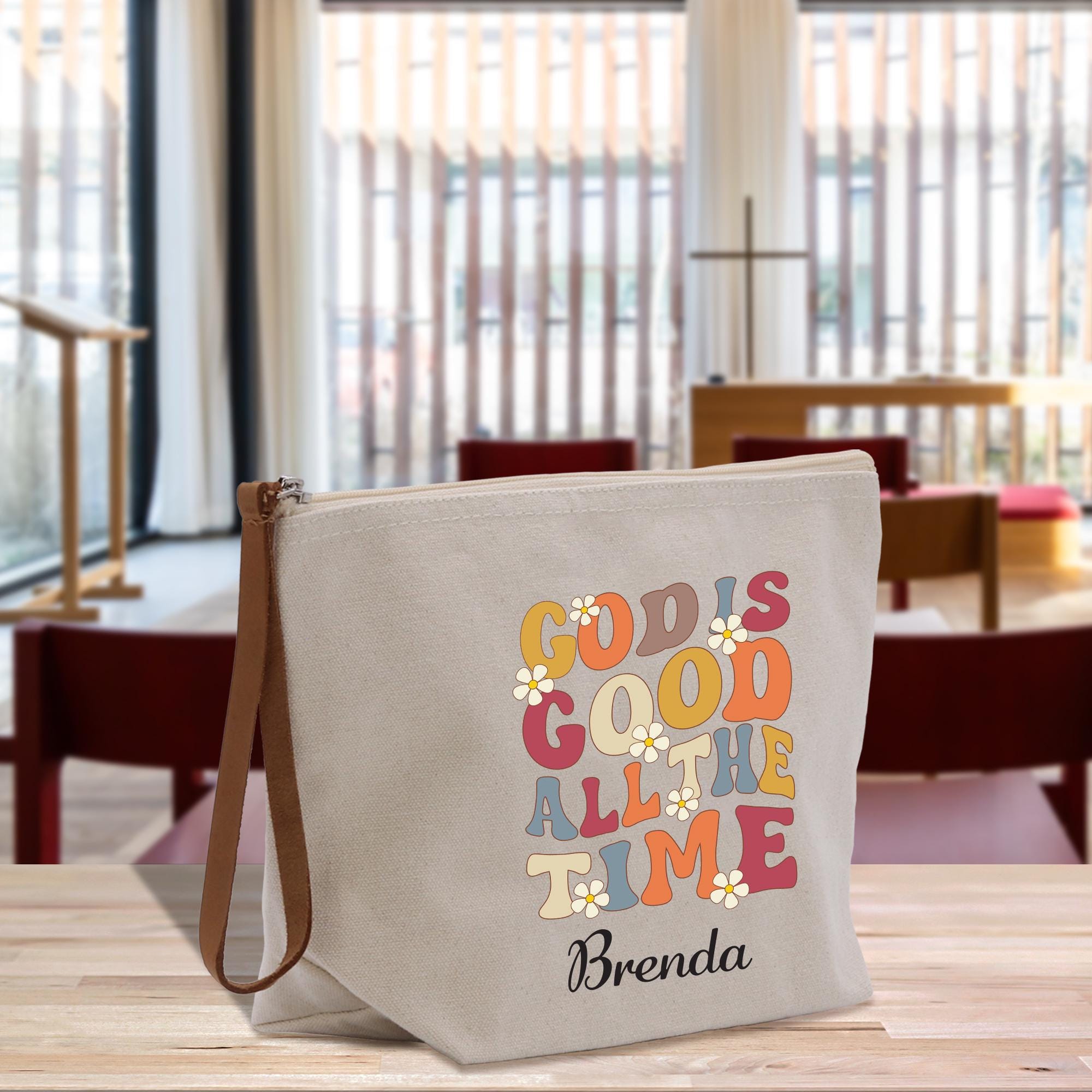 A beige tote bag with a colorful text design printed on it, sitting on a wooden surface.